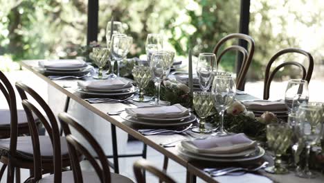 sunlit indoor wedding table setup with elegant glassware and floral decor