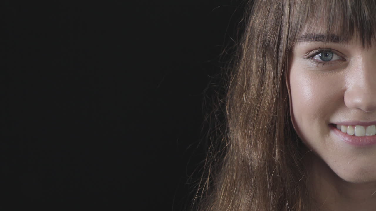 카메라를 보고 미소 짓는 귀여운 젊은 여성의 초상화 파란 눈 백인 여성 아름다움 검은 배경 복사 공간