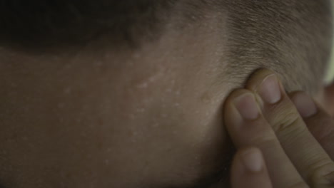 Male-touching-his-sweating-forehead,-close-up