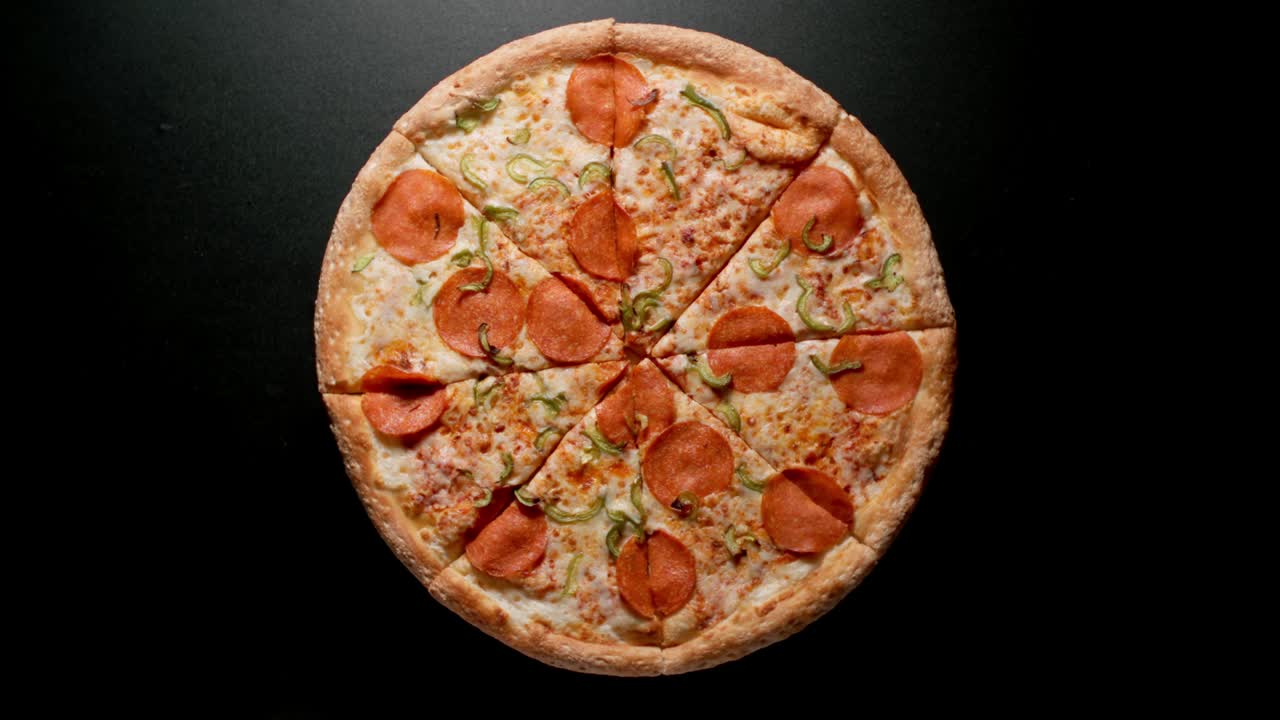 Circle Of Pizza Is Fast Rotating On A Black Surface, Time-Lapse