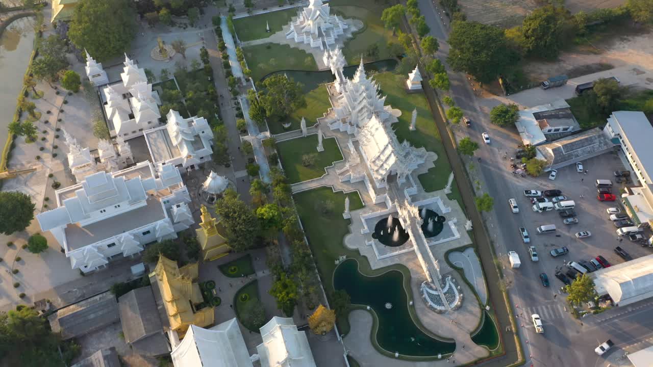vista aérea de las aves de los drones de wat rong khun, el templo budista gigante blanco y el templo dorado con montañas y paisajes en chiang rai, tailandia