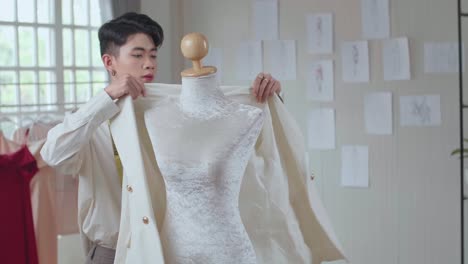 Fashion Designer Measuring and Fitting a White Blazer on a Mannequin