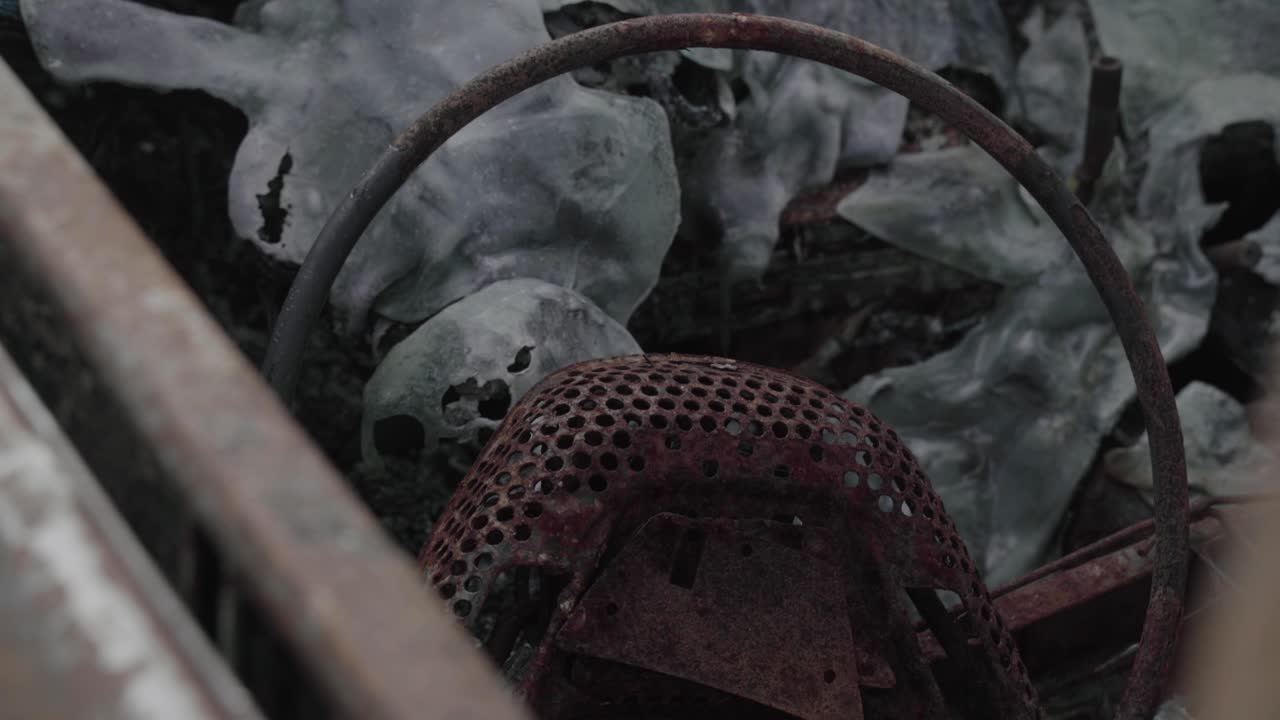 자동차 스티어링 휠의 금속 프레임 잔해 - 배경에 깨진 앞유리 유리 - 4k