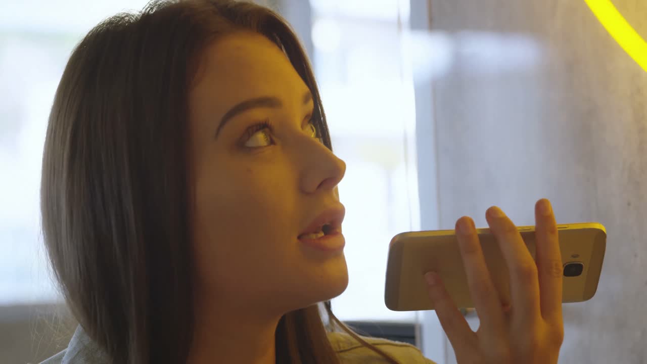 mujer hablando por teléfono móvil en la cafetería 4k