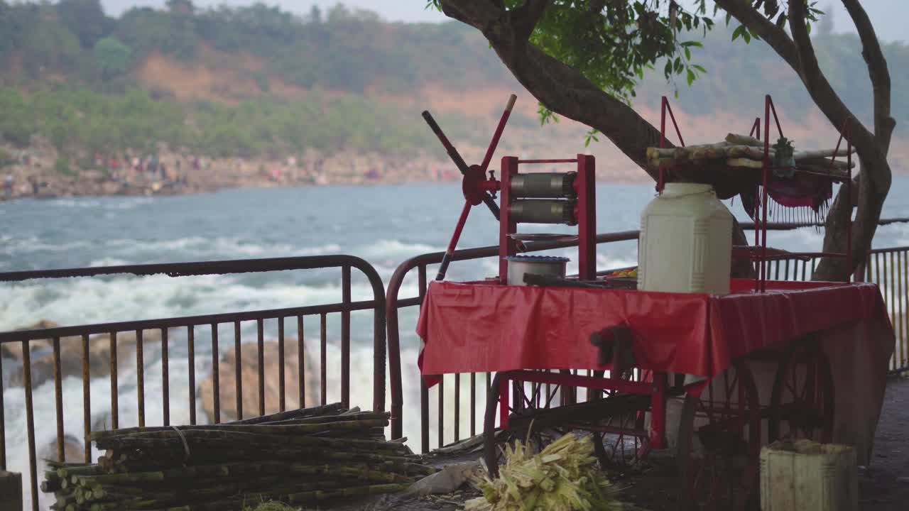 a sugarcane juice stall with Dhuandhar water falls in background at bhedaghat in madhya pradesh india
