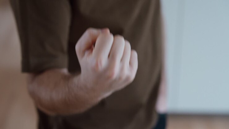 Primo piano di un uomo che fa un gesto osceno con il dito medio verso la fotocamera. Concetto di rabbia, insulto, ribellione, mancanza di rispetto, provocazione e comportamento maleducato.
