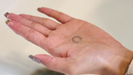 a coin falling into an open palm, captured in frames.