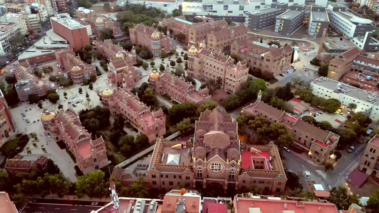 An aerial drone shot of Barcelona's beautiful castle-like building with a golden tower on each block