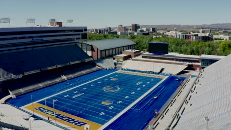 drone shot approaching and flying into the boise state broncos stadium on a sunny day.