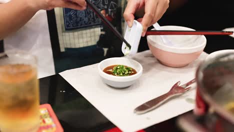 adding ingredients to a sauce dish