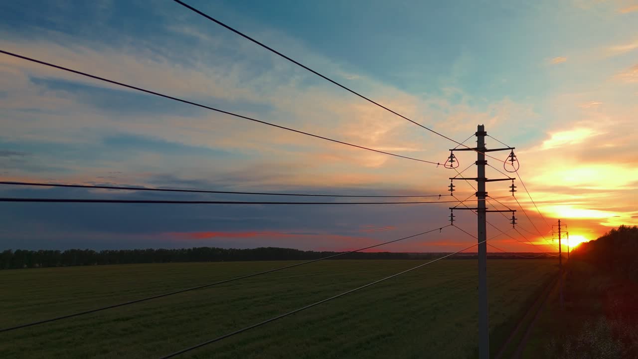 Sunset over a field with power lines