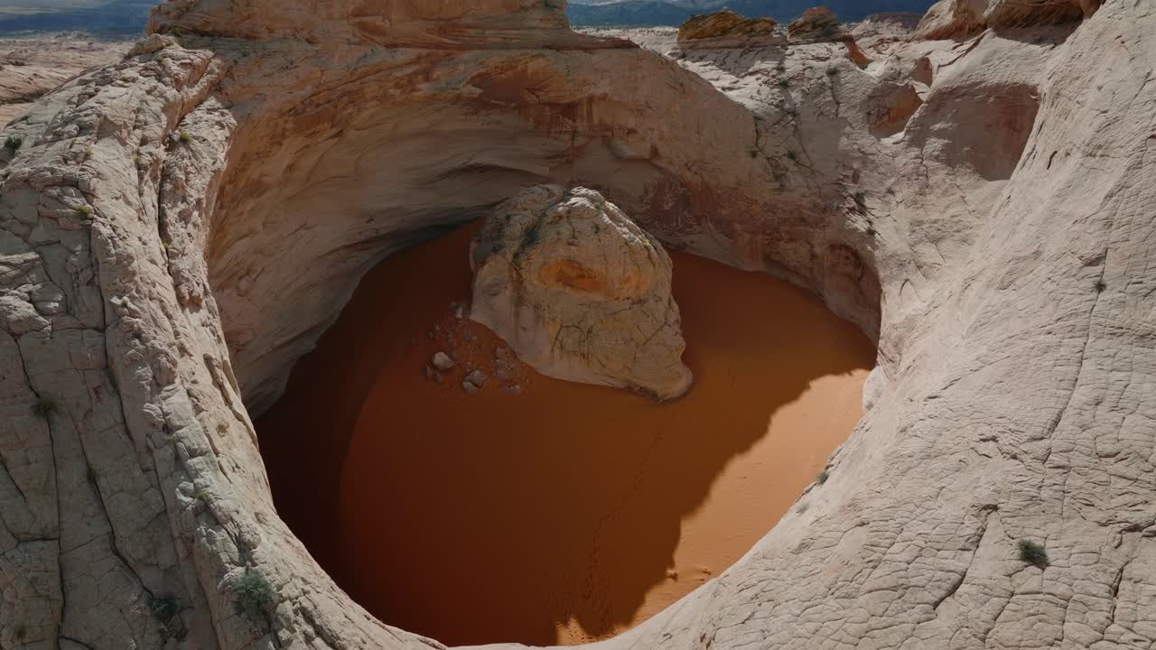 Cima del bacino di arenaria Cosmic Ashtray e pozza di sabbia arancione nel deserto dello Utah, ripresa con drone