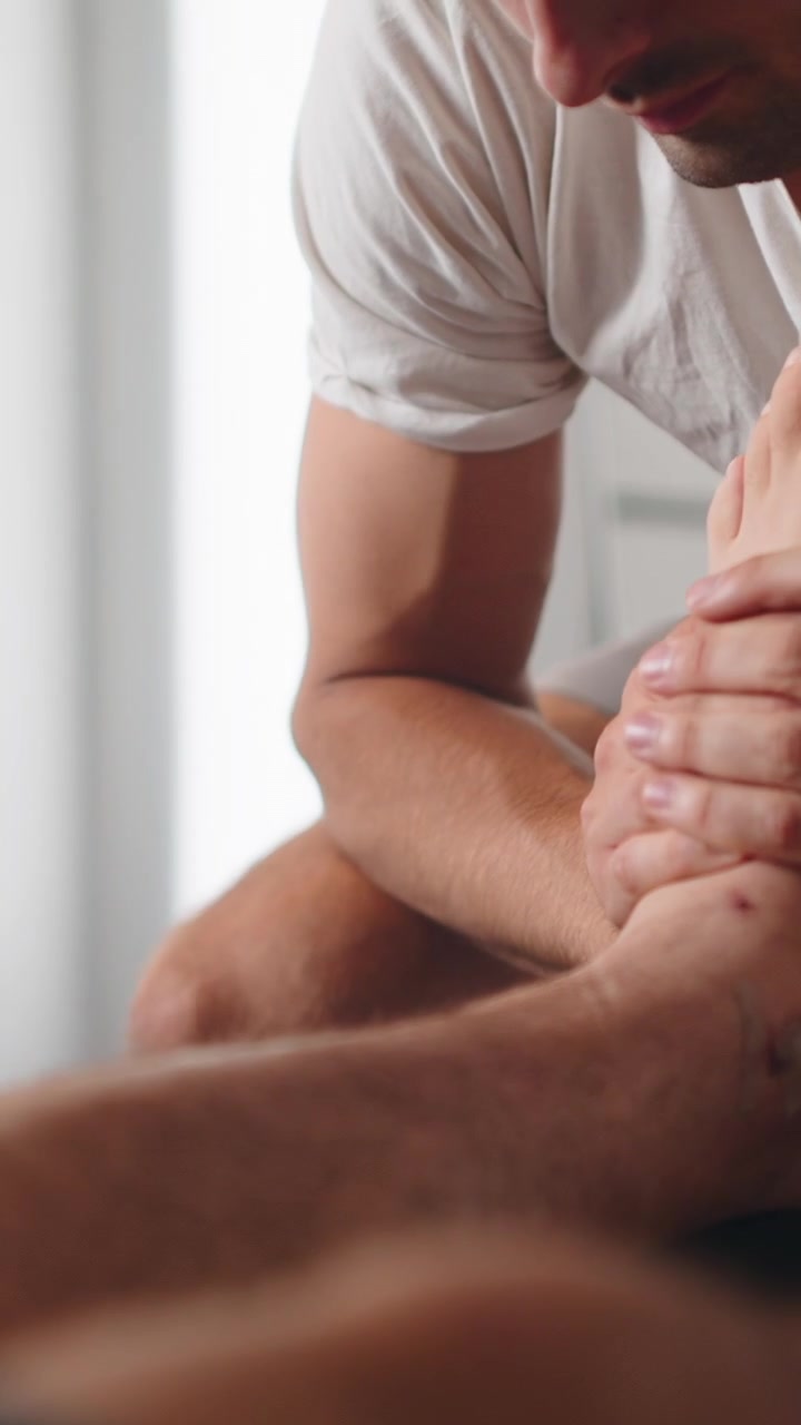 Physical Therapist Performing Ankle Massage on Patient