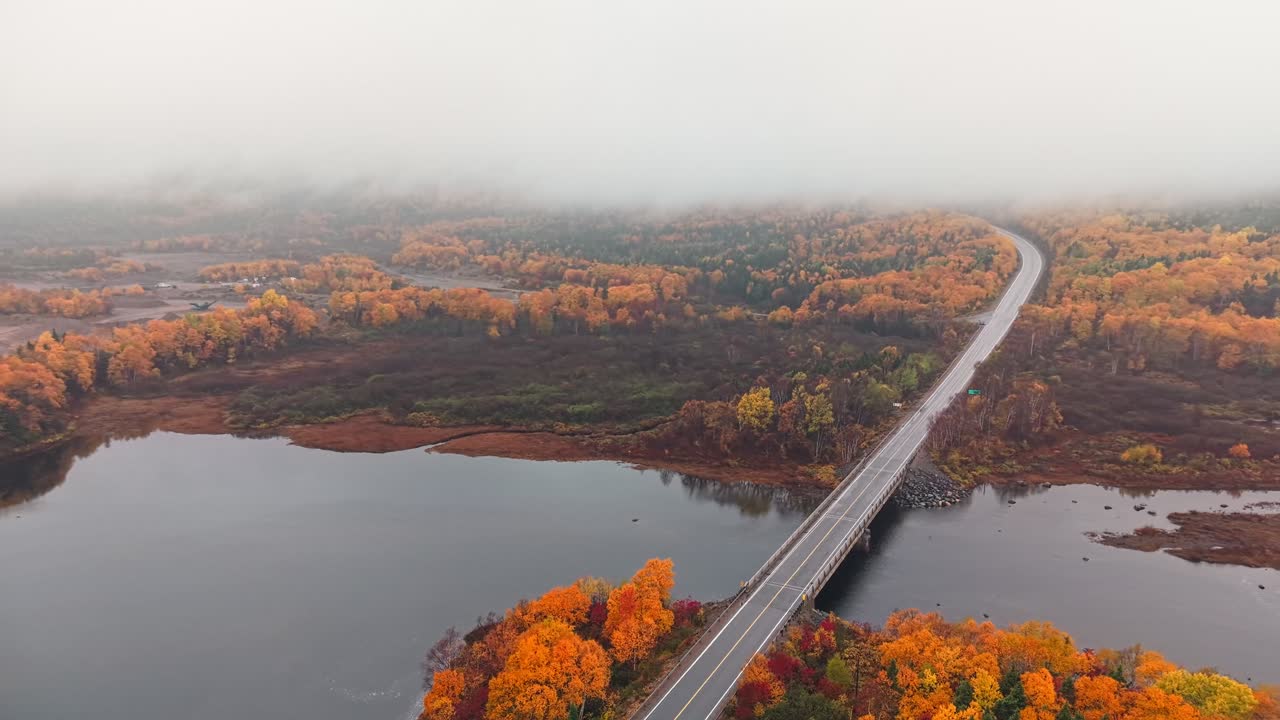 Drone footage shows highway curving through wilderness with sparkling water