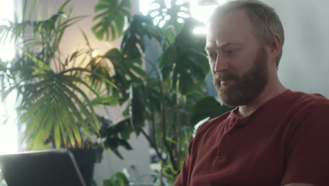 man talking on web call on laptop at home