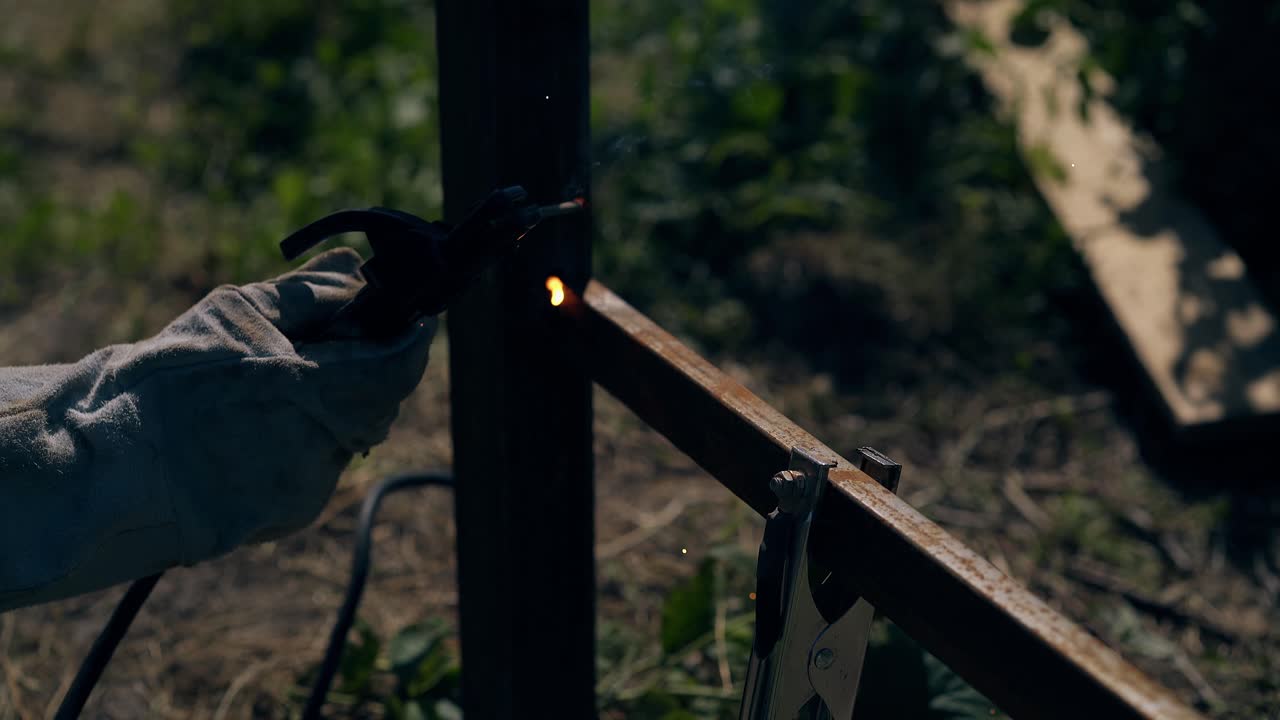 el reparador de primer plano utiliza equipos para soldar el cadáver de la valla