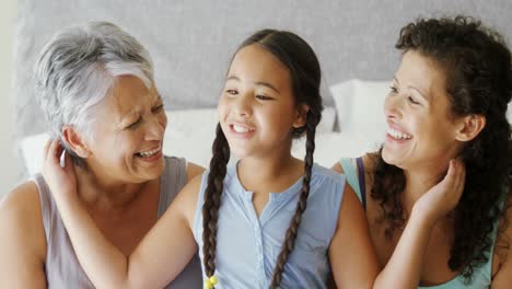 daughter kissing grandmother on cheeks in bed room 4k