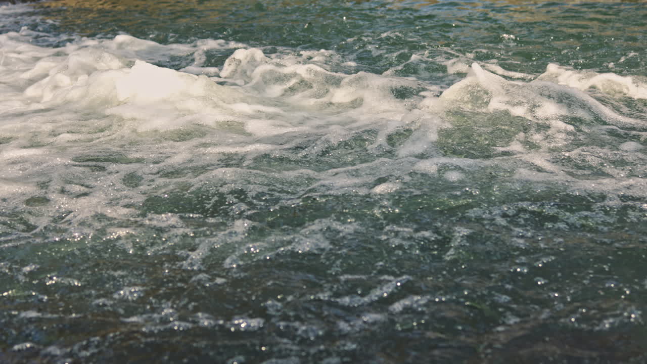 Flusso d'acqua da una sorgente. Forte corrente di acqua di fiume. Flusso d'acqua sui sassi in un fiume