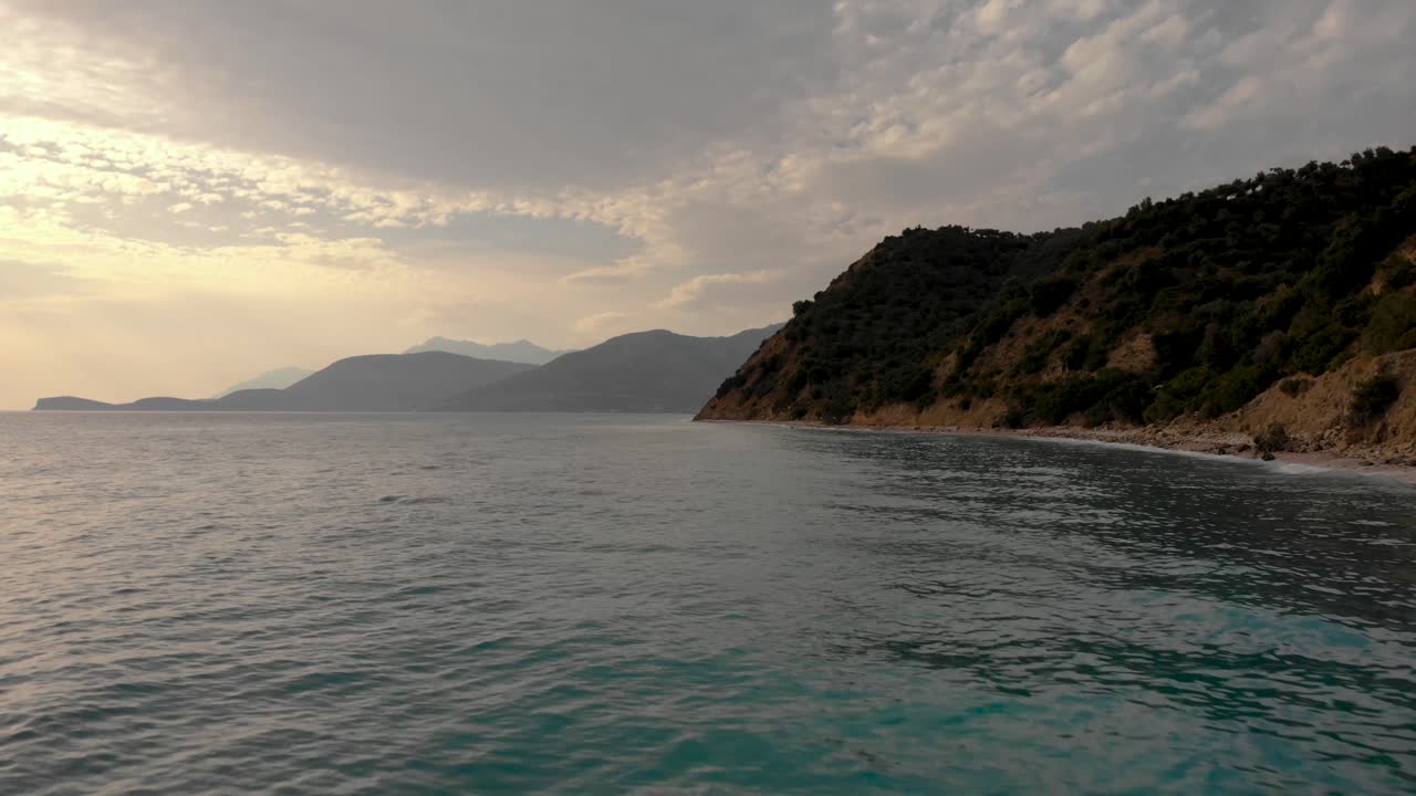 Misty cloudy sky at twilight over sea water on mountain and hills coastline in Mediterranean