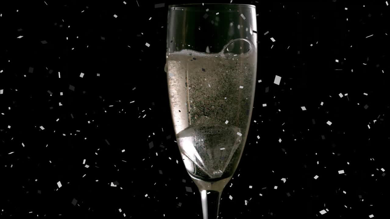 Champagneglas med bobler over faldende konfetti-animation på sort baggrund