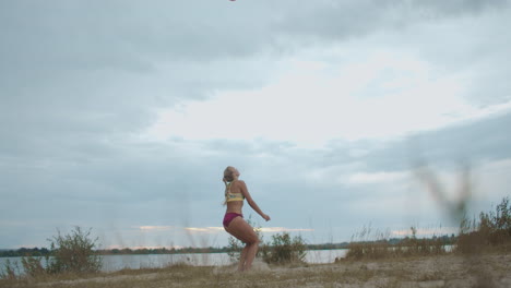 training of beach volleyball team on open sandy court female player is serving ball ladies sport team