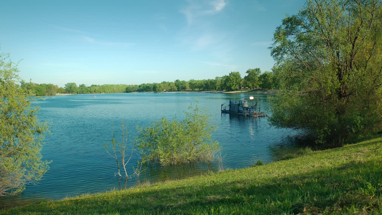 크로아티아 자그레브에 있는 자룬 호수의 조용한 푸른 물, 은 하늘 아래 푸른 초록색으로 둘러싸인
