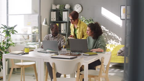 female manager helping diverse male trainees in office