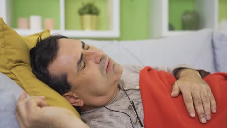 hombre enfermo postrado en cama toser en casa, teniendo un momento difícil.