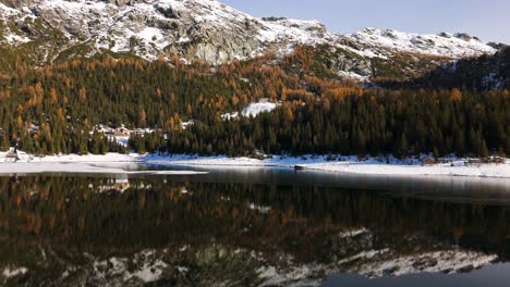 scenic winter mountain landscape reflected in alpine lake, italian alps aerial