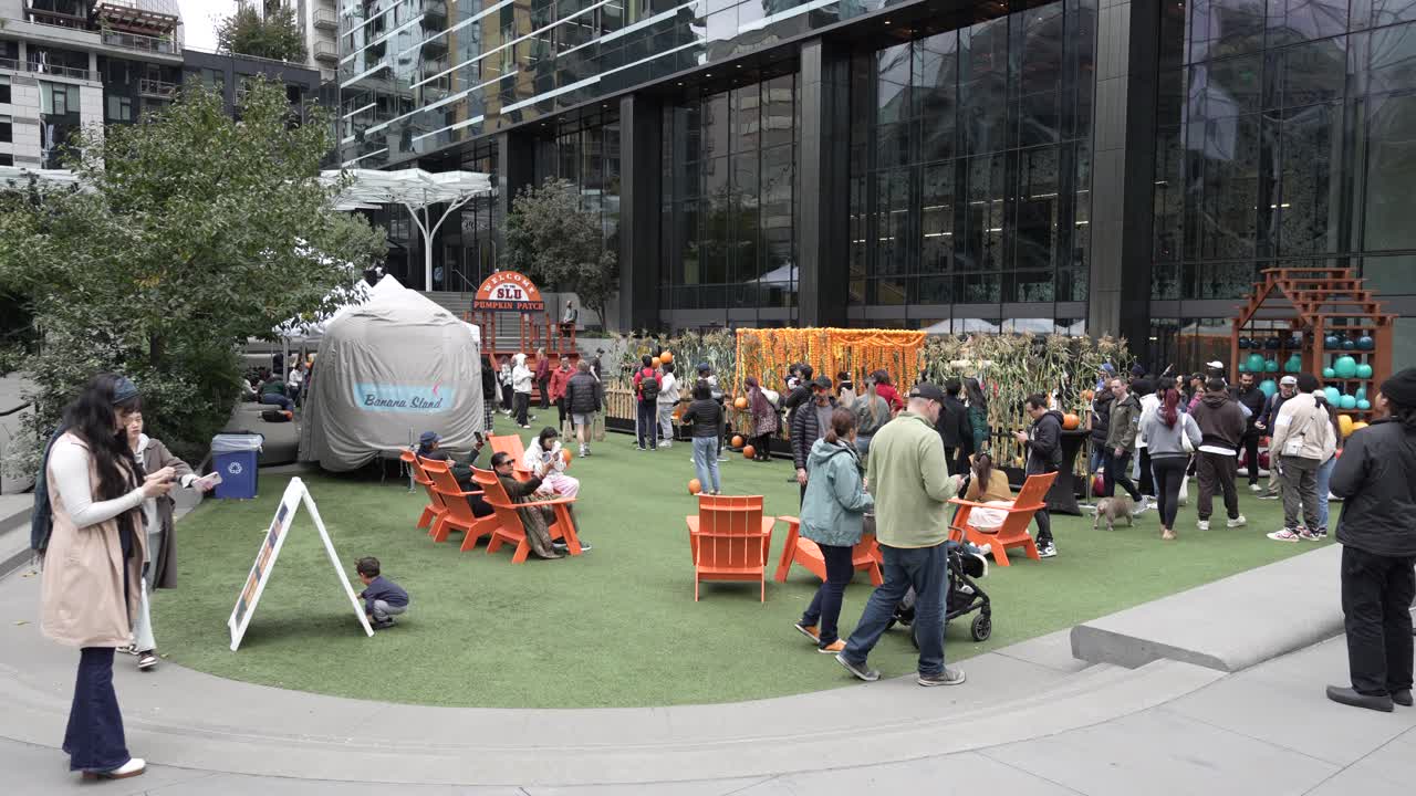 Families and visitors enjoy a recreational area near The Spheres at Amazon in Seattle. The space features seating, activities, and seasonal decorations, fostering a vibrant community atmosphere.