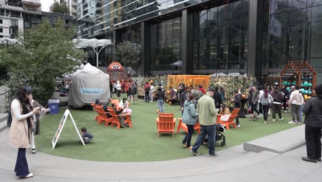 families and visitors enjoy a recreational area near the spheres at amazon in seattle. the space features seating, activities, and seasonal decorations, fostering a vibrant community atmosphere.