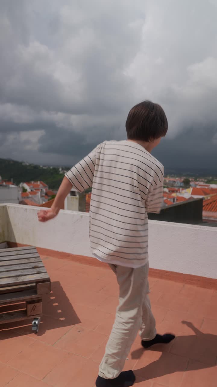 Child Dancing on Rooftop with City View