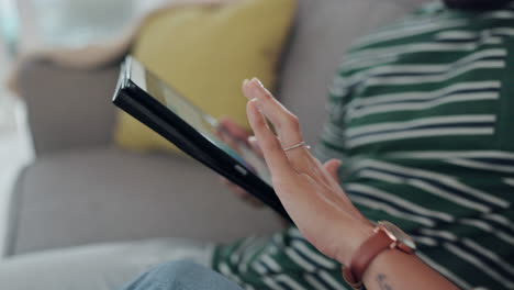 Hand,-tablet-and-couple-on-a-sofa-in-the-living