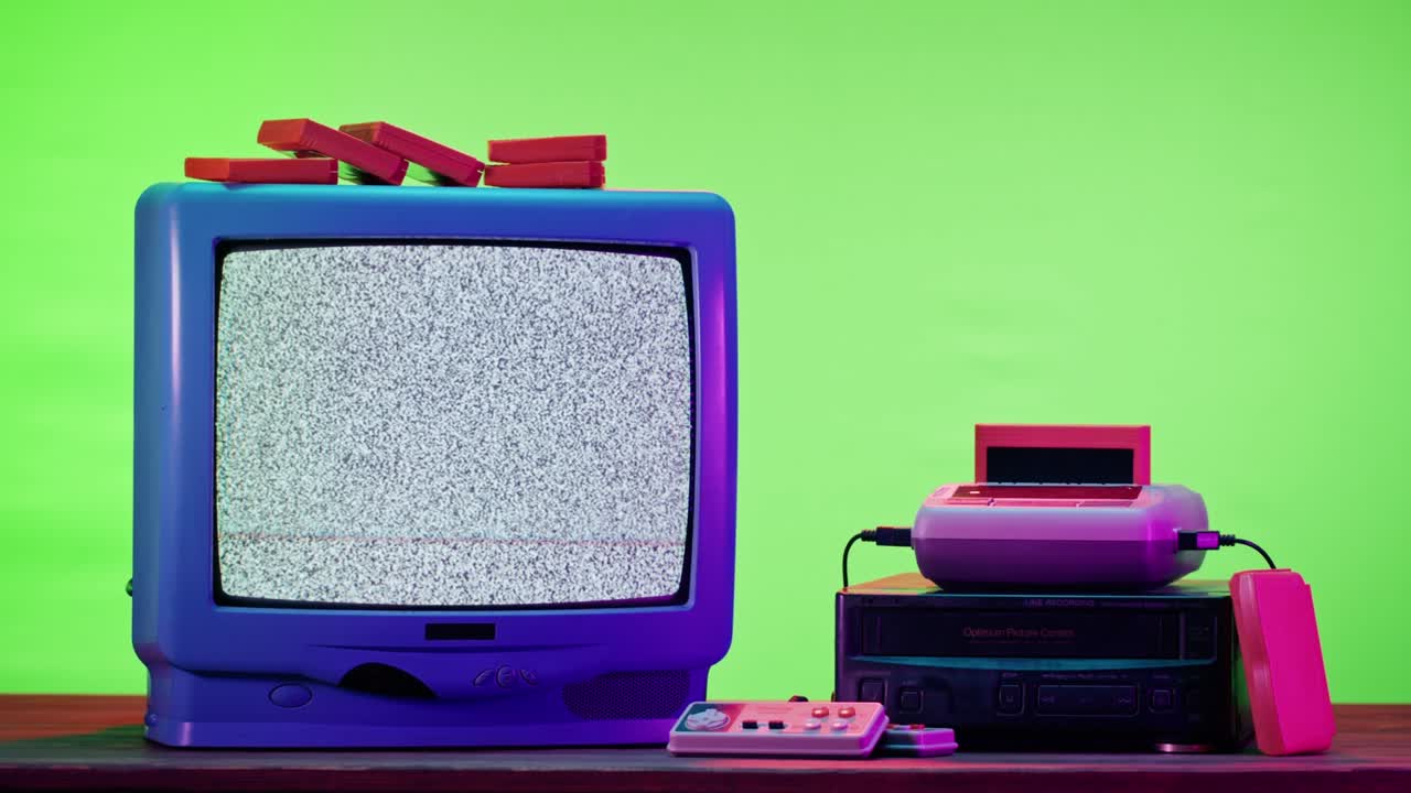 보라색 네온 배경에 회색 간섭 화면을 가진 오래된 텔레비전. 레트로 플레이스테이션을위한 빈티지 tv와 카트리지의 클로즈업. 고대 비디오 게임, 향수