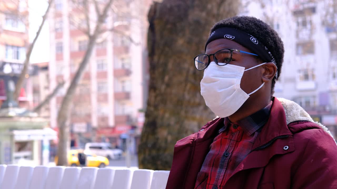 un joven negro se quita la máscara