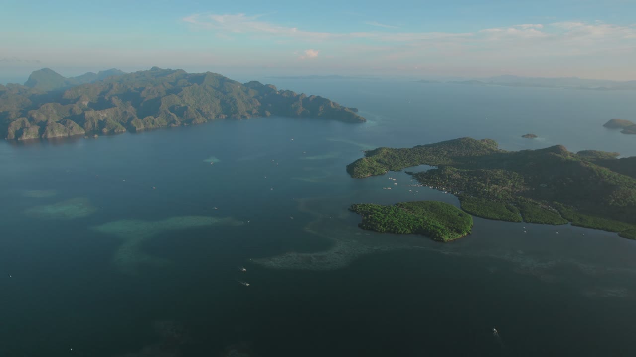 Aerial - lush islands surrounded by clear waters in the Philippines, showcasing natural beauty