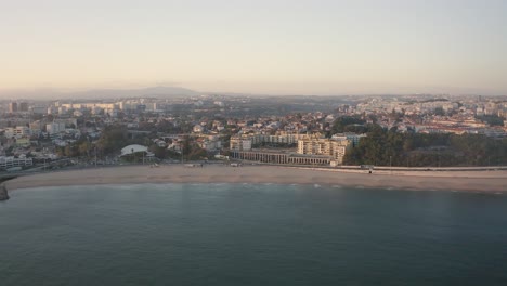 Vista-Aérea-De-La-Playa-De-Santo-Amaro-De-Oeiras,-Puesta-De-Sol-En-Portugal---Disparo-De-Drones-En-Estado-De-ánimo-De-Silueta