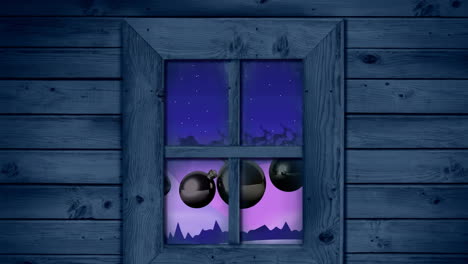 wooden window frame against christmas baubles hanging over winter landscape