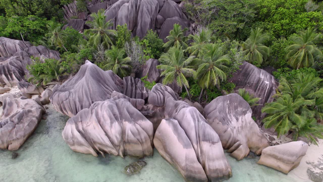 Ripresa drone spettacolare di una spiaggia con la bassa marea e roccia di granito di Anse Source d'Argent, La Digue, Seychelles 014 30fps