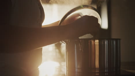 a housewife is cooking soup in a pot in her kitchen, the setting sun is shining from the window