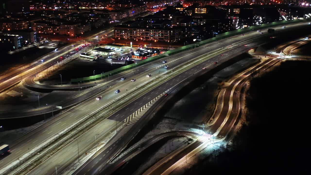밤에 항공 비행 교통 혼잡 교차로, 드론, 저녁에 현대 도시에서 도로 교차로의  다운 뷰. 많은 자동차가 빠른 움직임으로 바쁜 교차로 고속도로를 운전합니다.