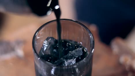 Slowmotion-bokeh-shot-of-a-barman-serving-a-vibrant-turquoise-cocktail