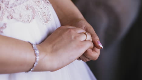 bride-wearing-white-dress-and-shiny-bracelet-shows-ring