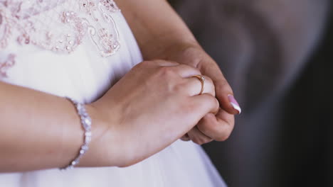 bride wearing white dress and shiny bracelet shows ring