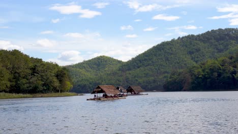 Rustic-traditional-wooden-boats-float-on-calm-sunny-river-through-green-forest