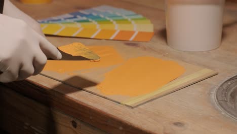 a worker applies a paint sample to a palette for color verification