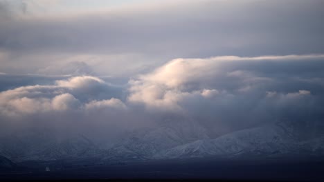 Nubes-Rodando-Sobre-Las-Montañas-Cubiertas-De-Nieve-Sobre-Las-Estribaciones-Del-Desierto-De-Mojave---Lapso-De-Tiempo-De-Invierno