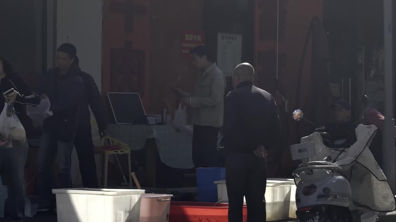 a bald man smoking in an active chinese street market. shot on 4k prores.