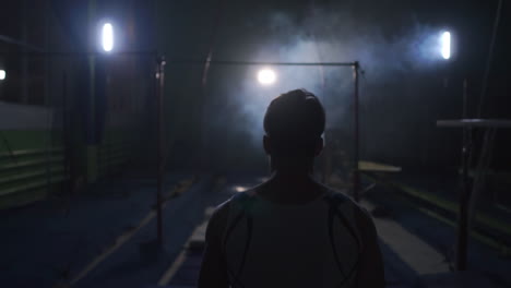 Gymnast-on-a-dark-background-on-the-crossbar-performs-spins-and-jumps-over-himself-in-the-air-in-slow-motion-and-around-the-smoke