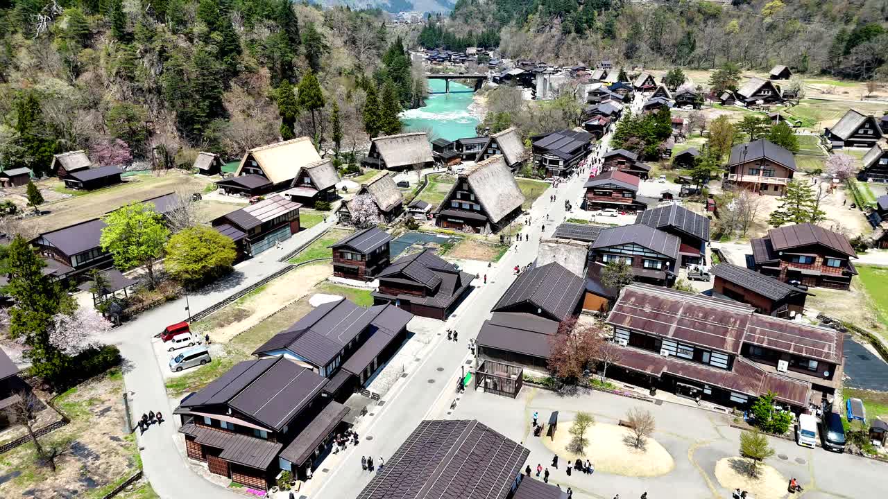Shirakawago, Japan, Aerial. Flyover of village centre with river in the background